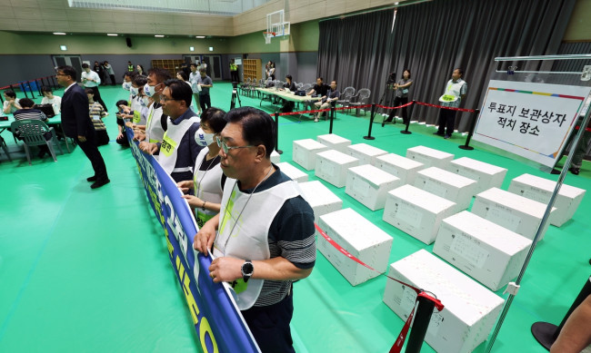 Observers for candidate Maeng blocking the opening of ballot boxes